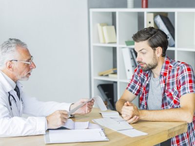 senior-doctor-talking-with-patient-office